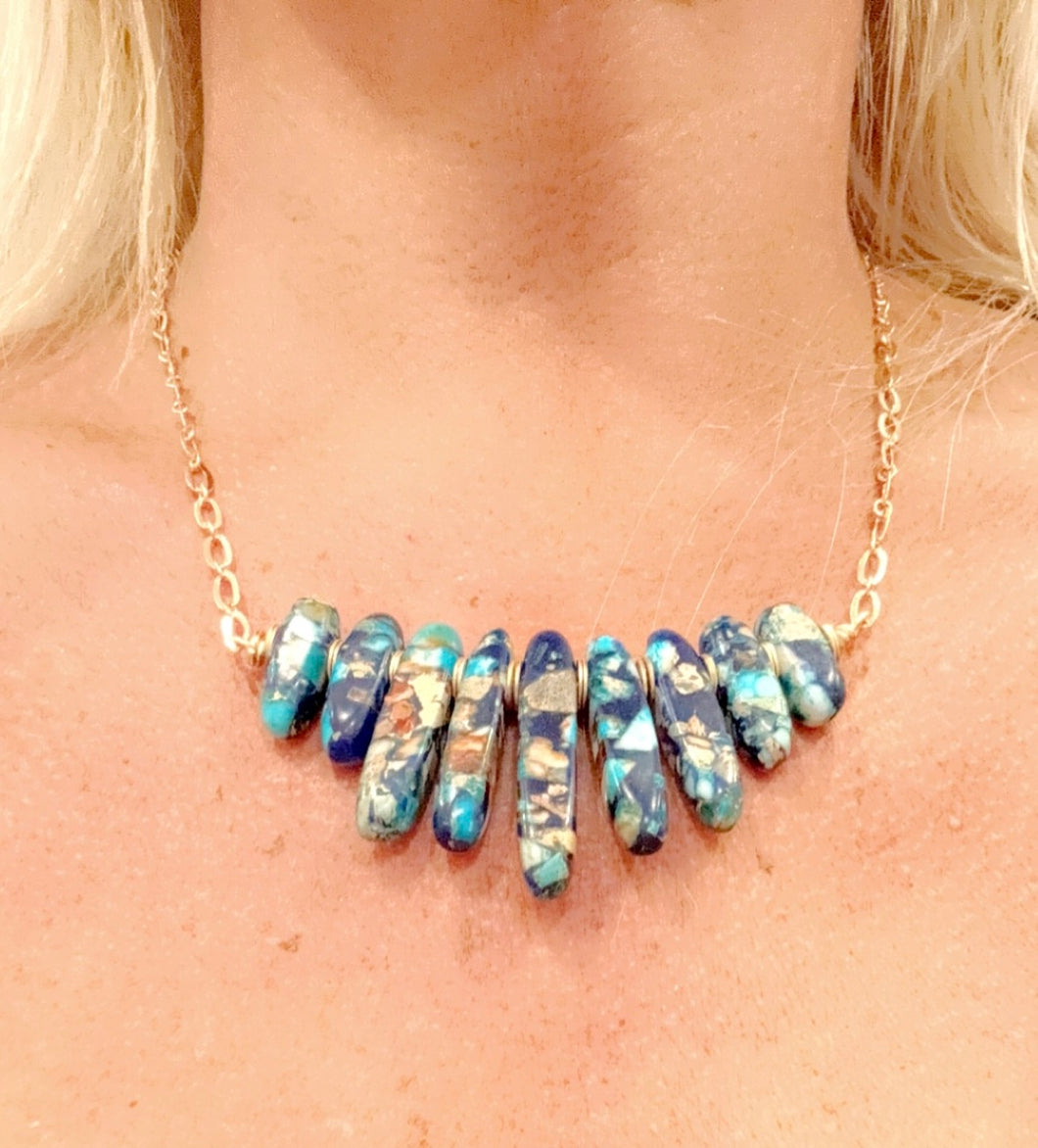 Marbleized turquoise stone necklace on gold chain.