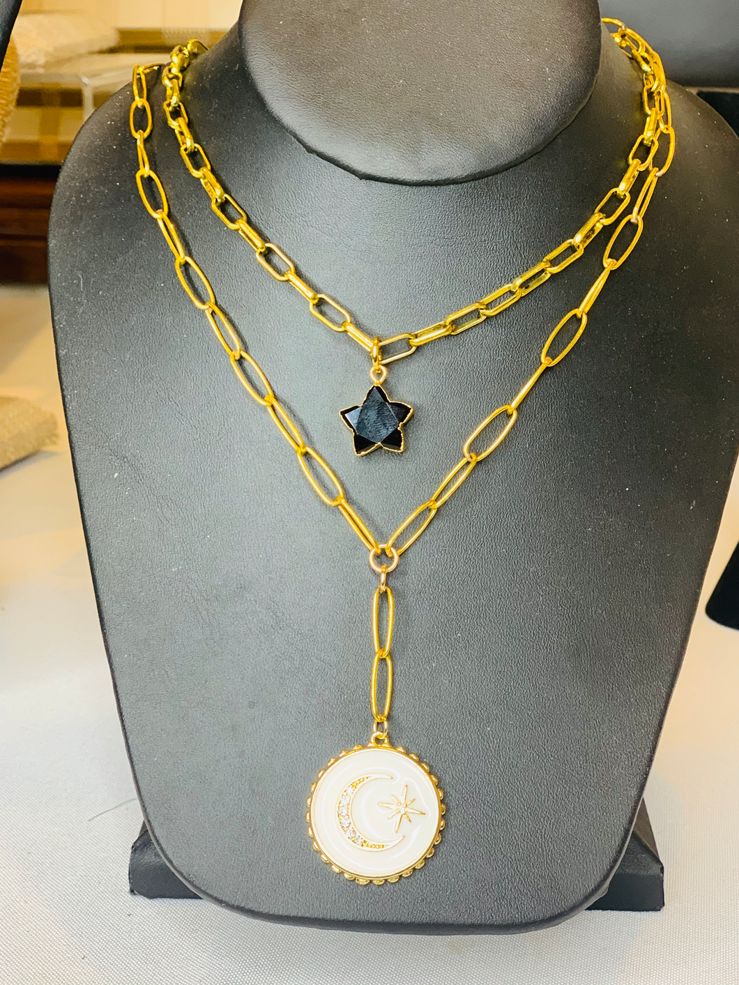White moon enamel pendant on gold link chain.